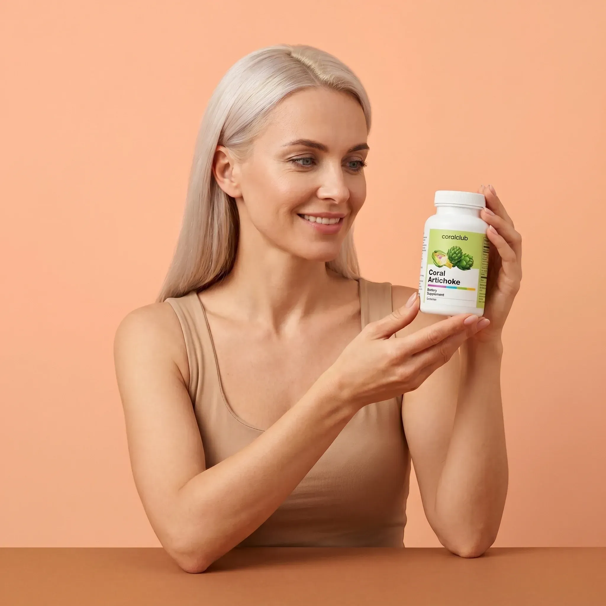 Woman holding Coral Artichoke supplement bottle against a peach background.