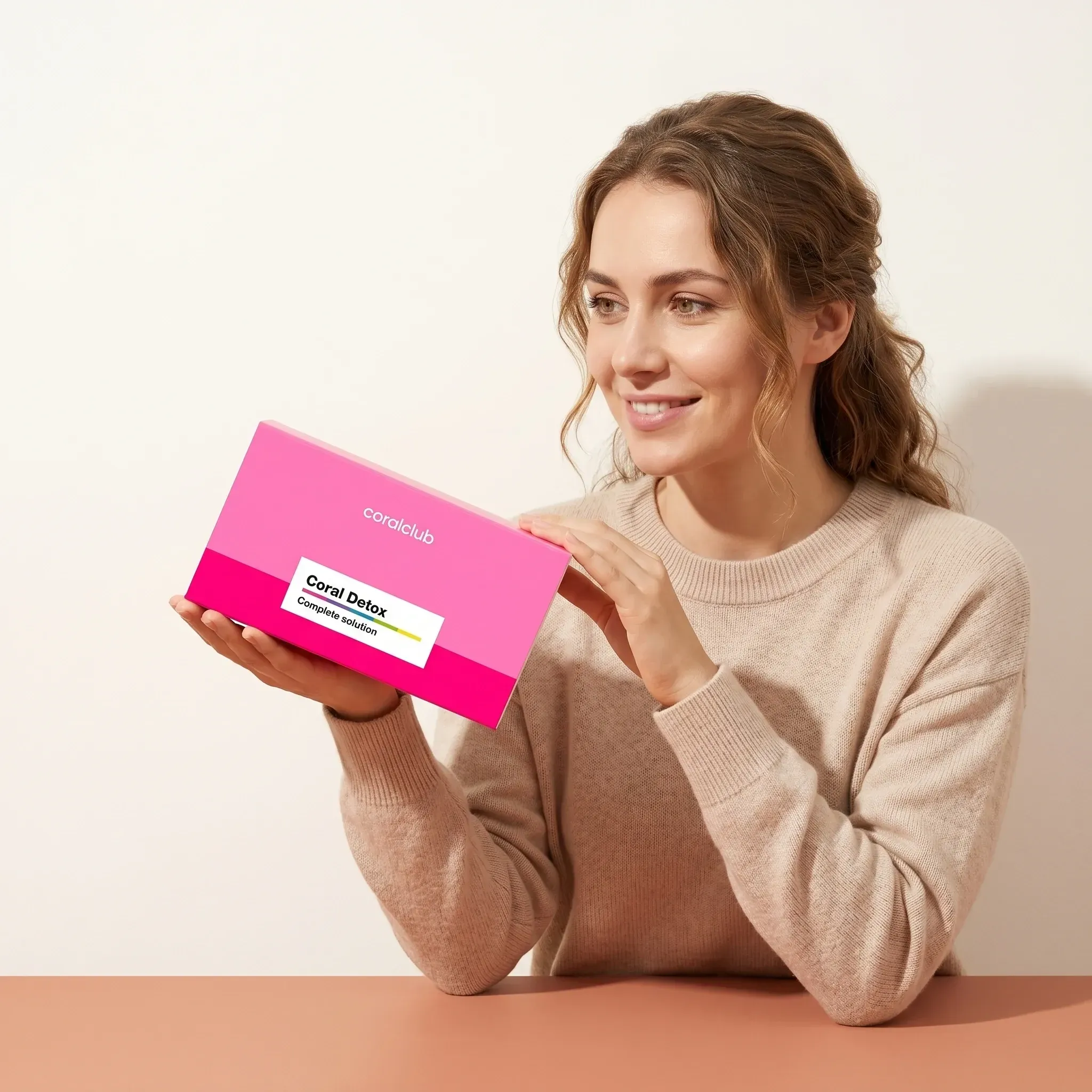 Woman holding Coral Detox box in a bright, minimalistic lifestyle setting.