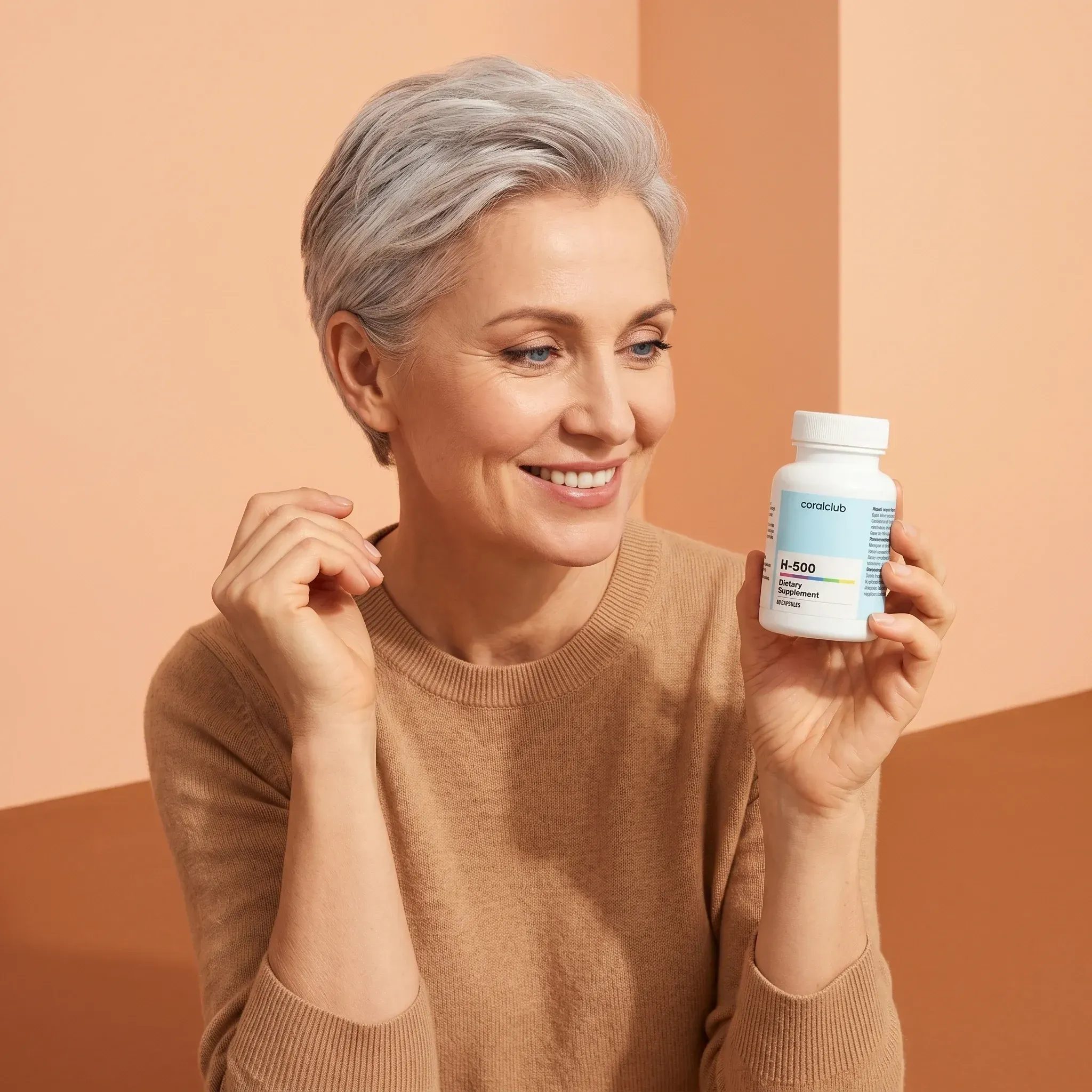 H-500 lifestyle image featuring a smiling woman holding the supplement bottle against a warm background.