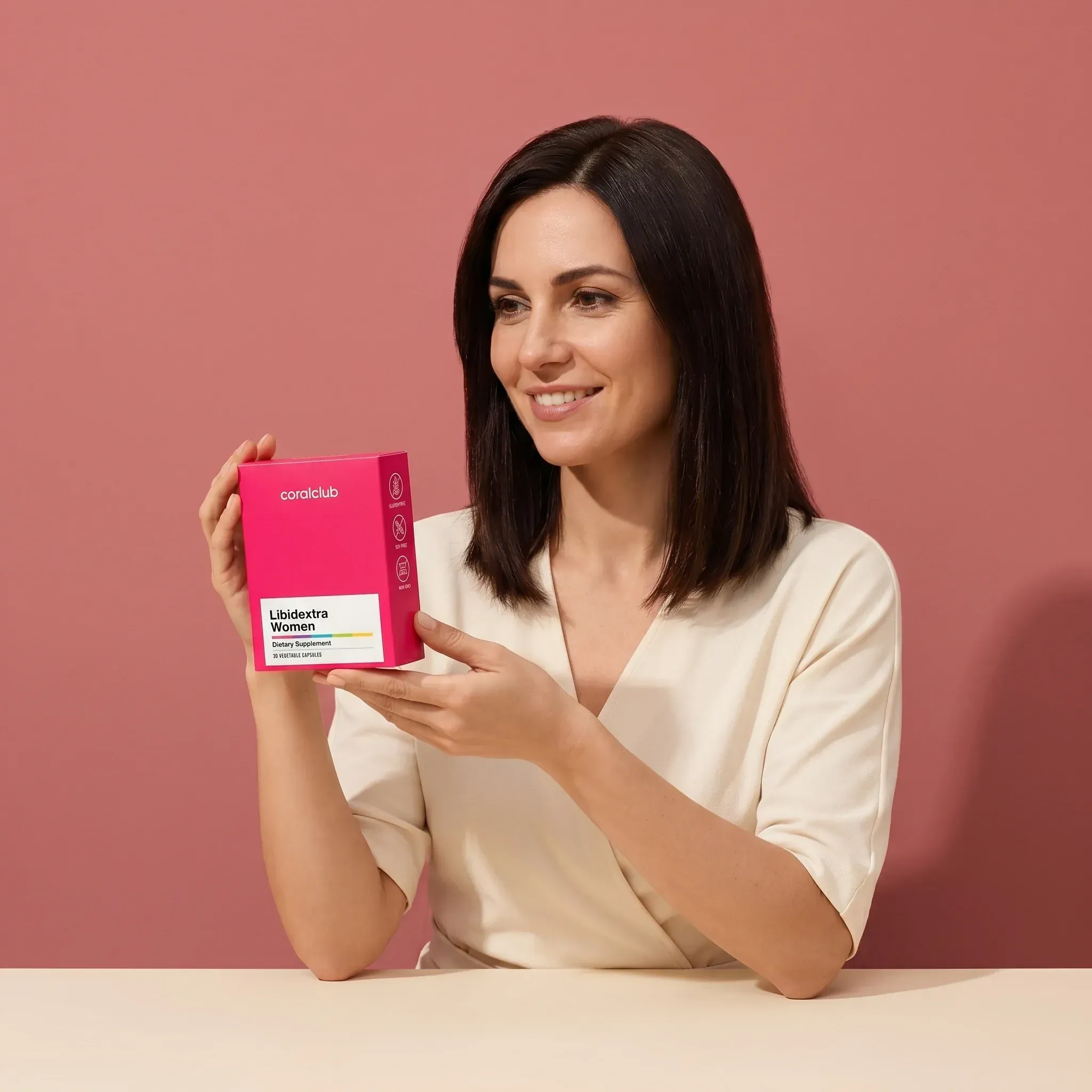 Libidextra Women lifestyle image with a woman holding the product box against a pink background.