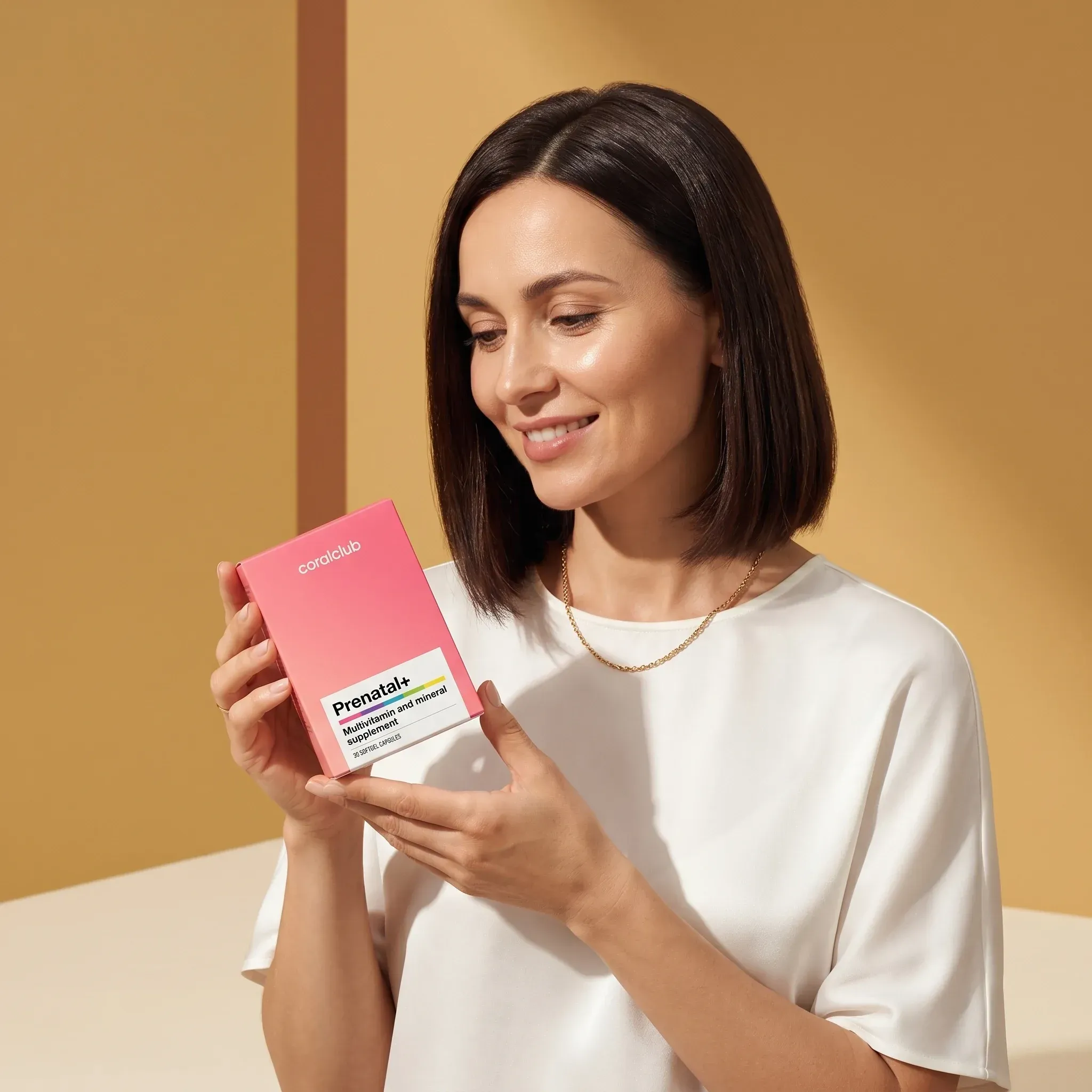 Woman holding Prenatal+ supplement box in a warm, stylish setting.