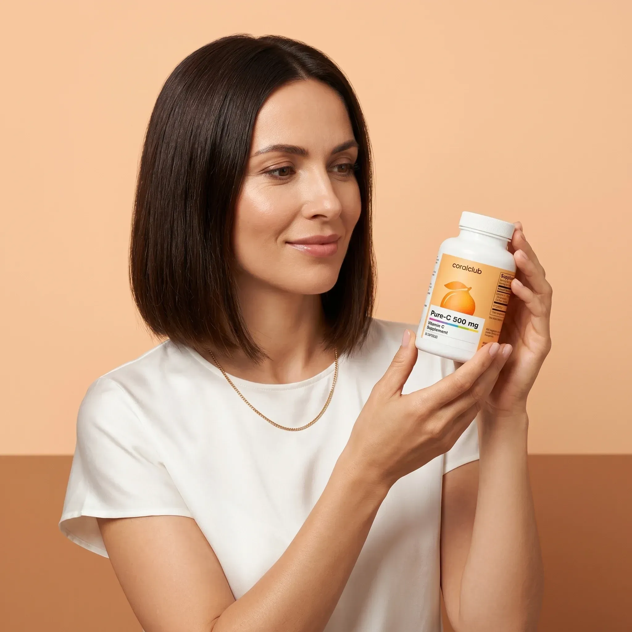 Woman holding Pure-C 500 mg supplement bottle against a warm background.