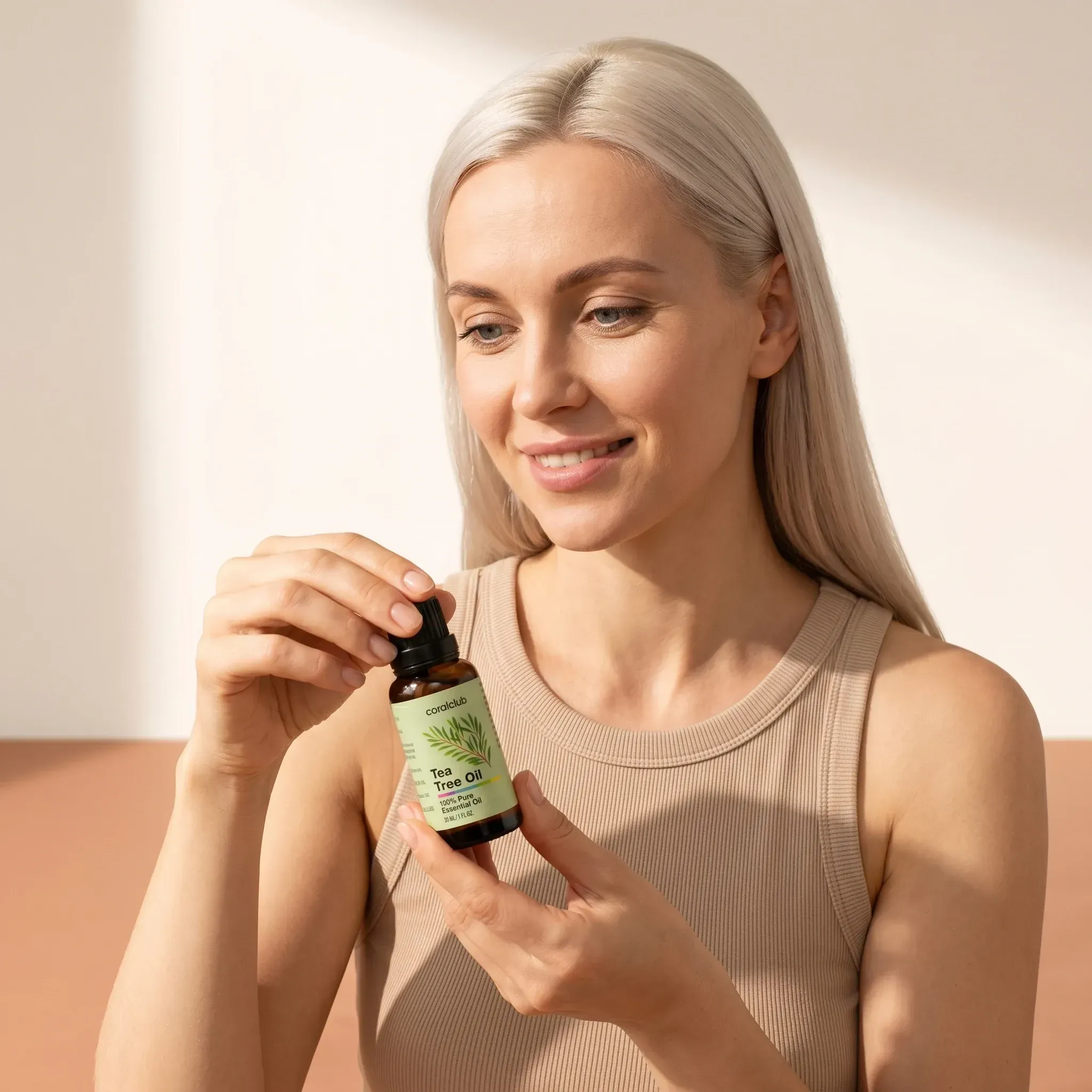 Woman holding Tea Tree Oil bottle in a bright lifestyle setting.