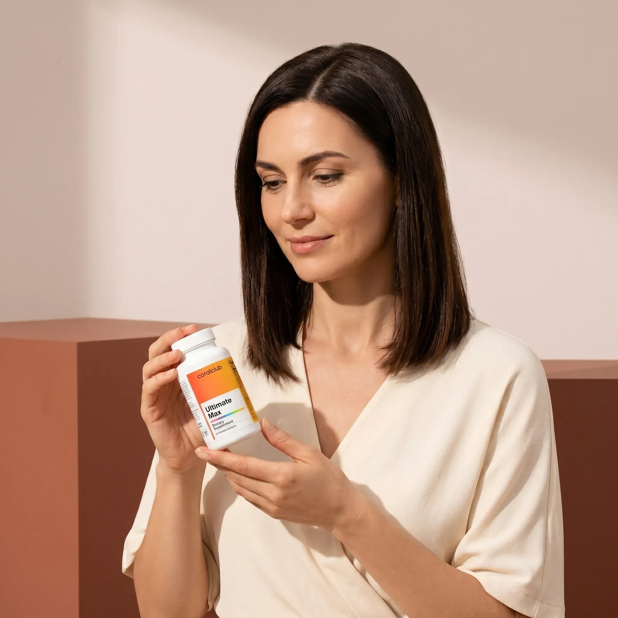 Woman holding Ultimate Max supplement bottle in a modern lifestyle setting.