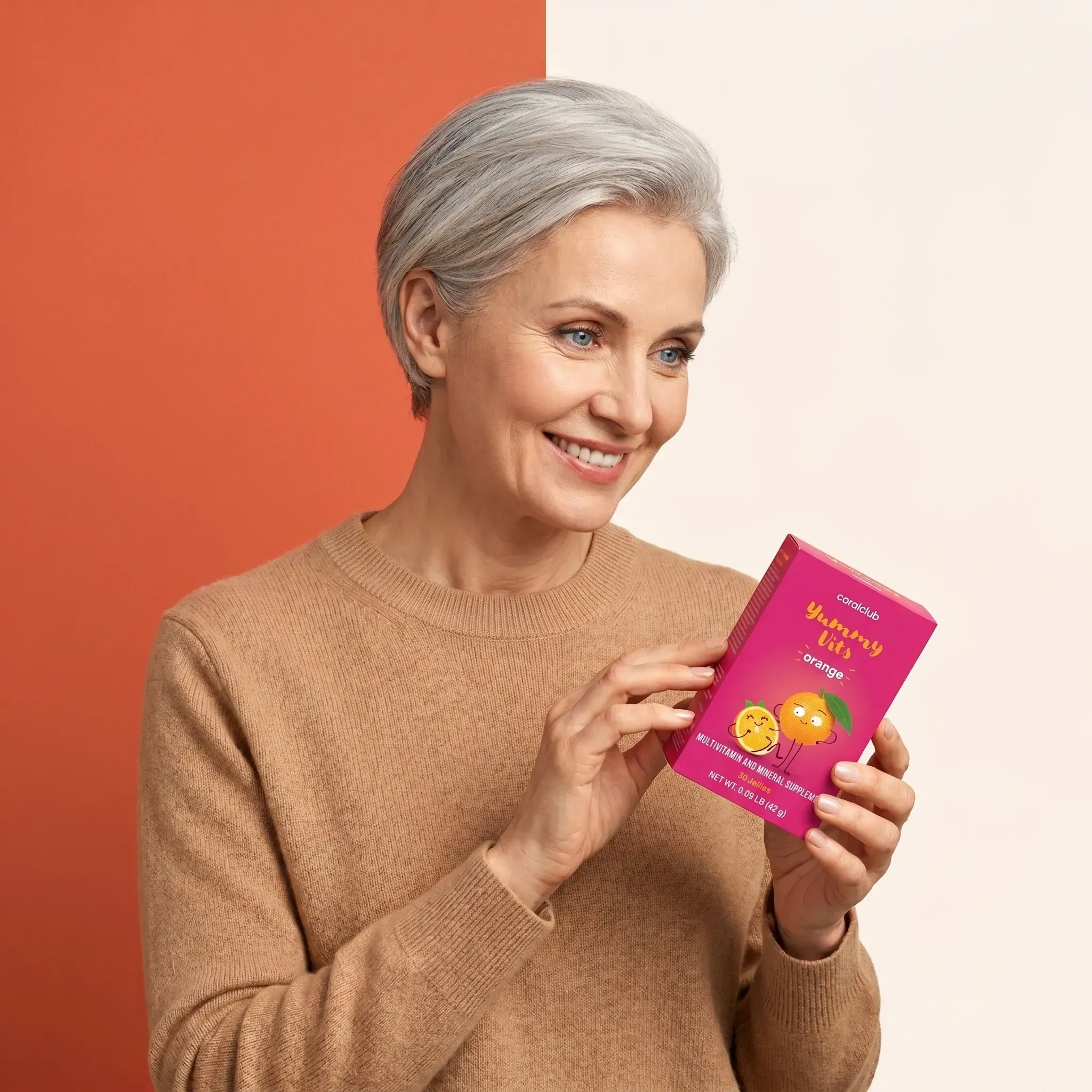 Yummy Vits Orange lifestyle image featuring a smiling woman holding the product box.